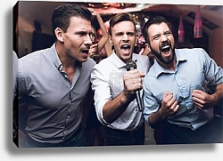 Постер Three men sing at a karaoke club. Young people have fun in a nightclub. They are very cheerful and they smile.
