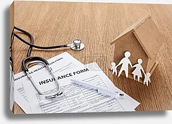 Постер close-up view of insurance form, insurance health claim form, pen, stethoscope, house model and paper cut family on wooden table