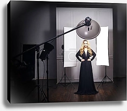 Постер Красивая модель позирует в черном платье в фотостудии