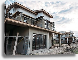 Постер close-up shot of contemporary building construction with scaffolding under cloudy sky