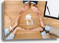 Постер People making circle with hands on wooden table with paper house and family inside, life insurance