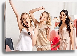Постер beautiful smiling multiethnic girls in nightwear singing karaoke at pajama party in bedroom