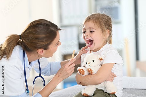 Доктор осматривает горло ребенка
