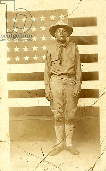 World War I soldier with American flag in background, 1914-18