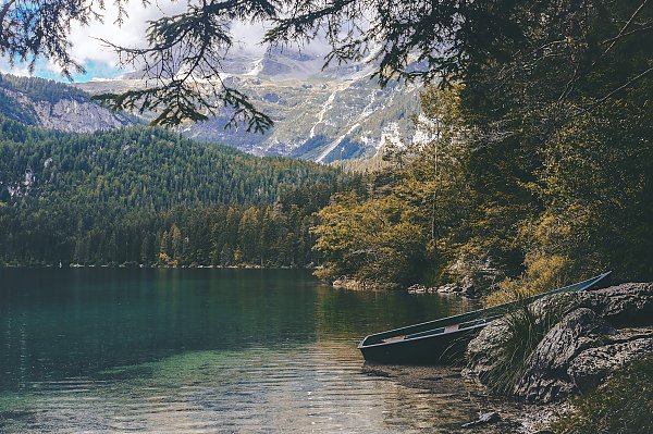 Деревянная лодка на берегу озера в горах