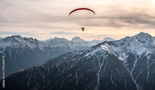 Полет параплана над заснеженными вершинами Кавказских гор