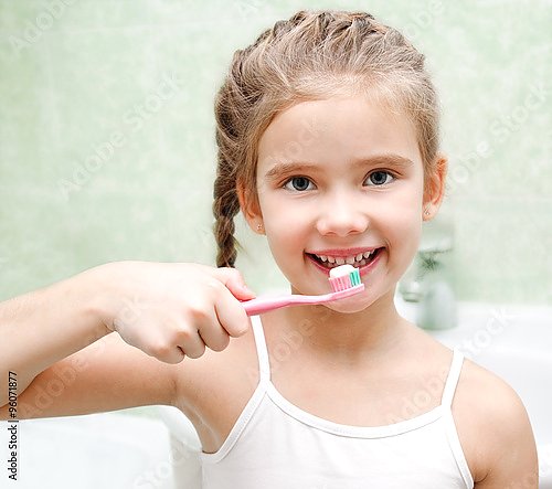 Милая маленькая девочка чистит зубы