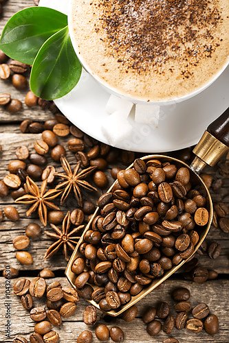 Чашка кофе с жареными кофейными зёрнами на деревянных досках