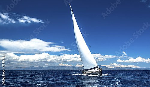 Одинокая яхта в море при облачном небе