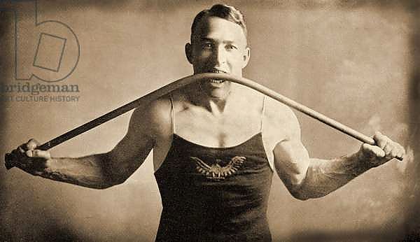 Californian Strongman Mr P. A. Linebarger bends an iron bar with his teeth,San-Francisco c.1922