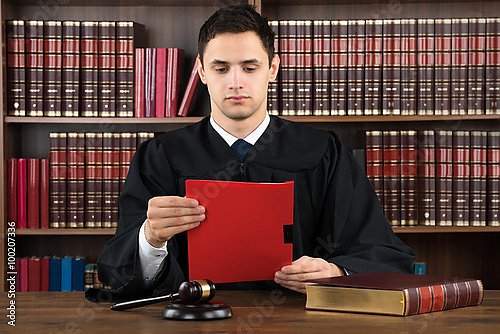 Судья, читающий юридический документ за столом