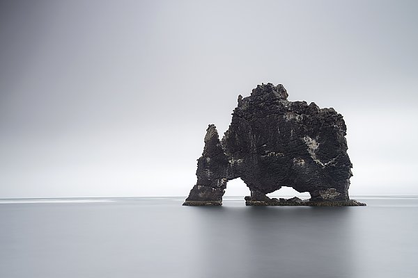 Черная арка скалы в море