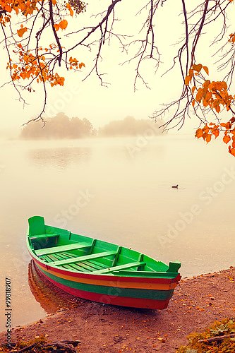 Туманное осеннее утро. Деревянная лодка на берегу реки