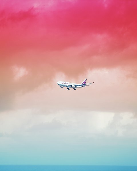 Самолет в розовом небе над морем