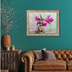 «Три пурпурных цветка в стеклянной вазе » в интерьере гостиной с зеленой стеной над диваном