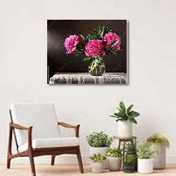 «Три пышных розовых пиона в вазе» в интерьере современной комнаты над креслом