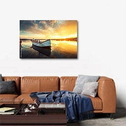 «Закат над спокойным озером с лодкой, отражающейся в воде» в интерьере современной гостиной над диваном
