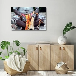 «Абориген с трубкой» в интерьере современной комнаты над комодом