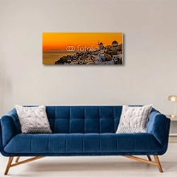 «Греция, Санторини. Красно-желтая панорама» в интерьере современной гостиной с синим диваном