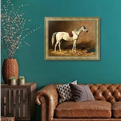 «Серый в конюшне» в интерьере гостиной с зеленой стеной над диваном