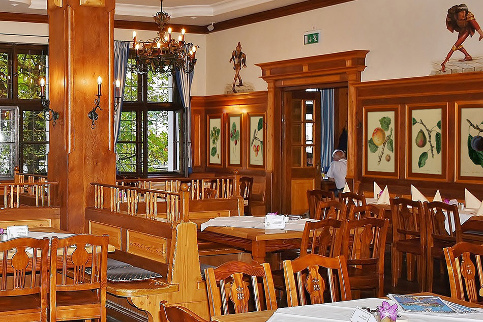 Серия гравюр с фруктами в рамах на стене ресторана в стиле ретро с деревянной мебелью